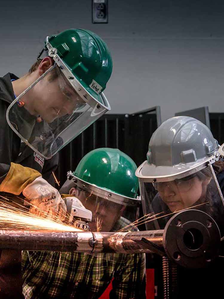 Students cutting into pipe.