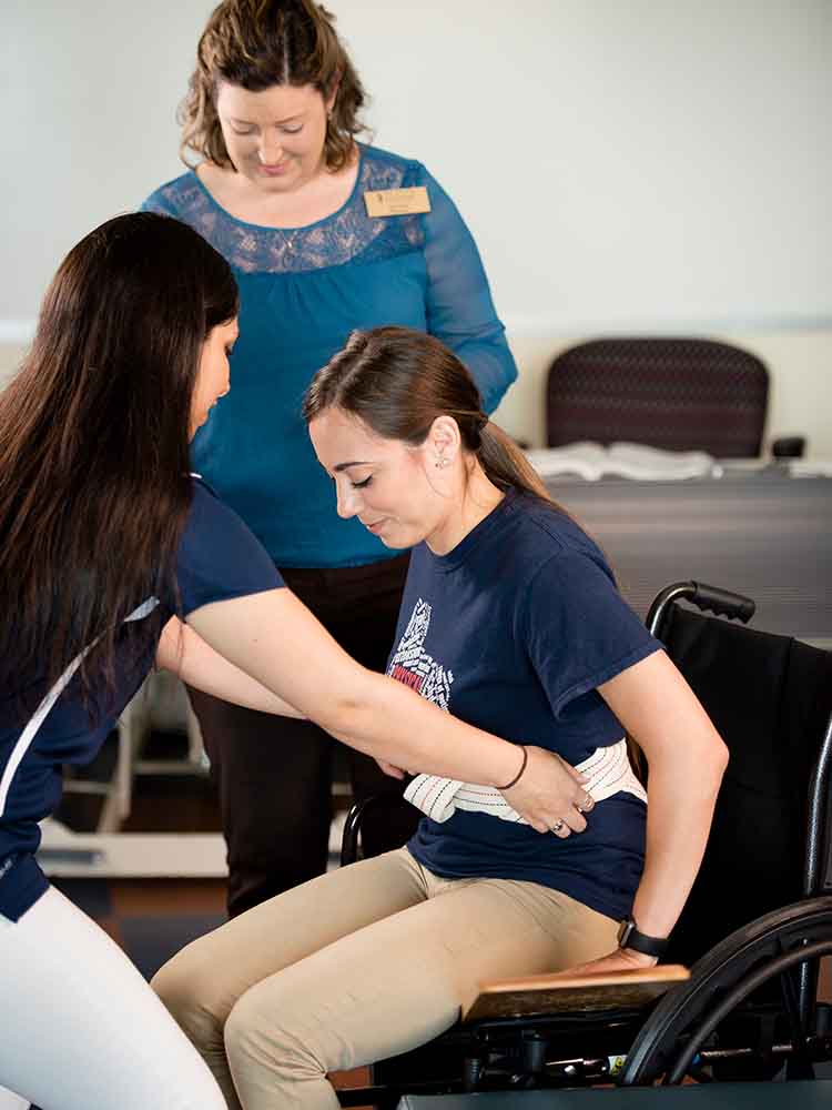 pta helping patient get up out of wheelchair